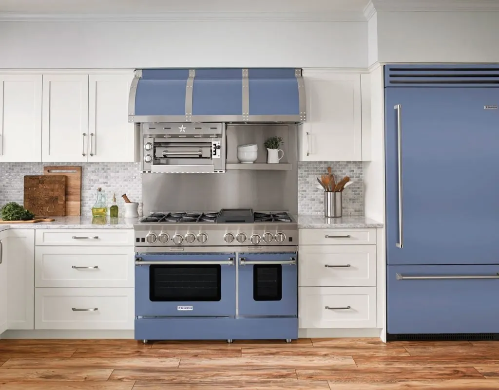 White kitchen with periwinkle blue professional range, hood and matching refrigerator